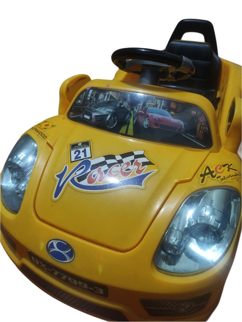 Yellow Racer Ride-on Car with Remote Control (Category: Remote Control Toys) located in Manila. Submitted by mswrdplnt (Listing ID 1439091100, Image 2). Description: - Yellow ride-on car - Includes remote control - Features headlights - Detailed dashboard - Chrome-like hubcaps - Visible wire inside - Remote control with charging port INCLUDES: CHARGER & REMOTE CONTROL (BOTH WORKING) DEFECTIVE!!! hindi na umaandar, kasi may napigtas na wire. wala 