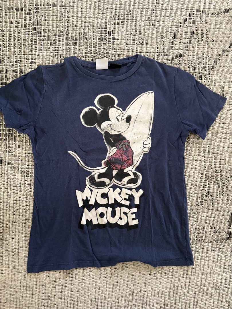 Zara Mickey Mouse Surf T-shirt (Category: Tshirts & Polo Shirts ) located in Binan City. Submitted by morticias_vault (Listing ID 1439107225, Image 1). Description: - Zara navy blue t-shirt - Features a Mickey Mouse surfing graphic (front and back) - Crew neck and short sleeves - Size: S (fits kids aged 12) - Made in Portugal Color may vary due to lighting.