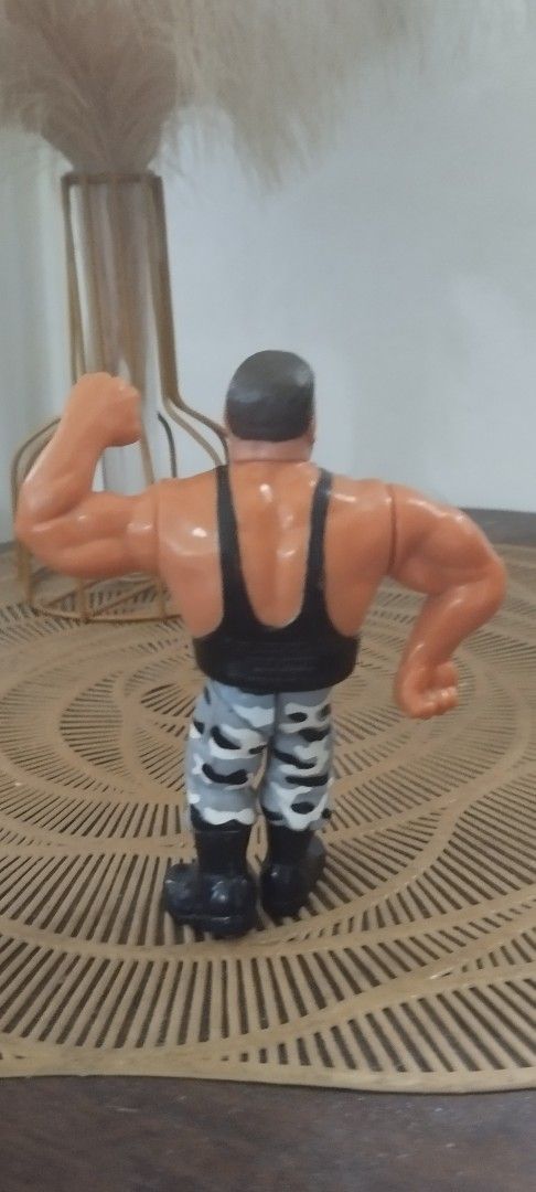 1991 Hasbro WWF Bushwacker Butch action figure (Category: Action & Battle Toys) located in Manila. Submitted by ventajetoyz625 (Listing ID 1439281740, Image 3). Description: - Vintage wrestling action figure - Muscular wrestler design - Black tank top and camouflage pants - Detailed with a beard - Flexing arm pose - Made of plastic - "Gimmick" not working - What you see is what you get.