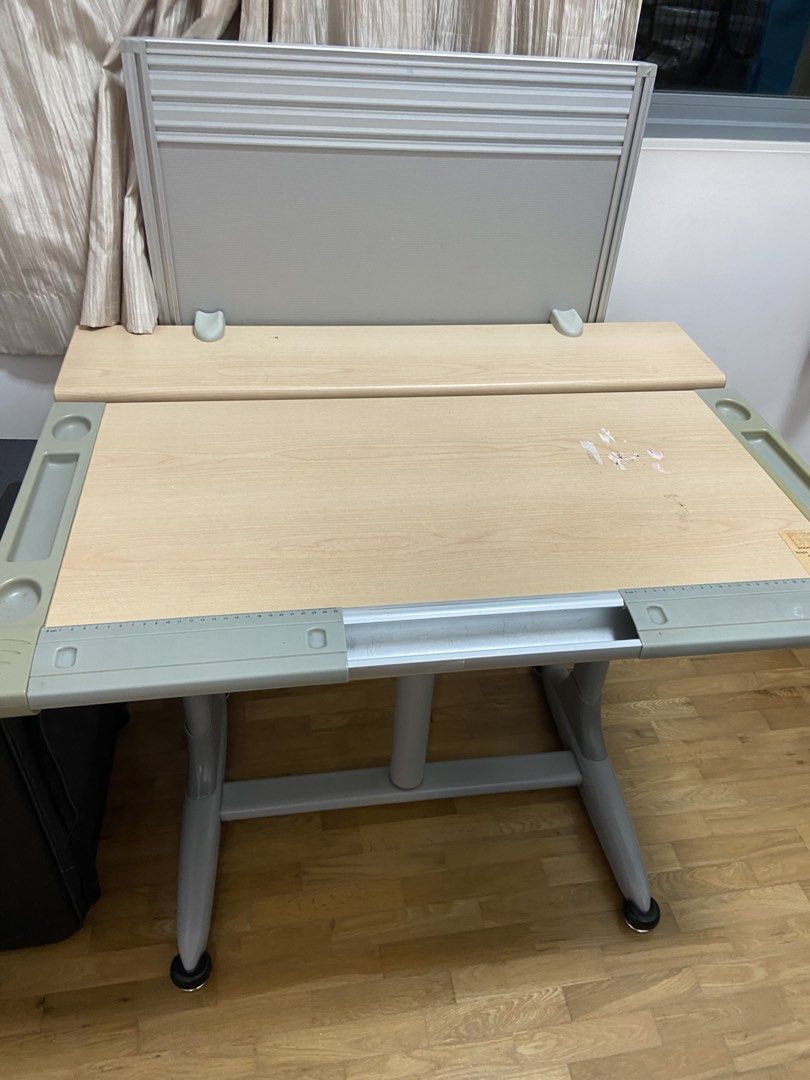 Adjustable Study Table (Category: Tables & Sets) located in Singapore. Submitted by sylviel (Listing ID 1439310781, Image 2). Description: - Adjustable study table - Tilting tabletop and backboard - Suitable for children and adults - Height adjustable - Dimensions: 60cm x 61cm x 2.25m .