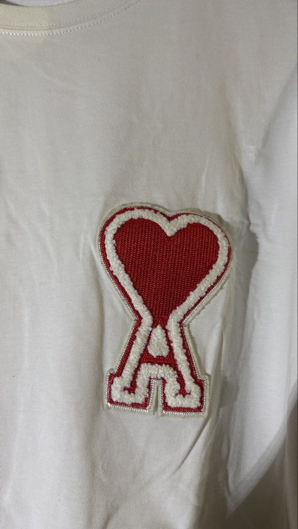 AMI Paris Heart Logo T-shirt (Category: Tshirts & Polo Shirts ) located in Quezon City. Submitted by mogsmogs (Listing ID 1439391864, Image 2). Description: - AMI Paris T-shirt - Features the iconic red heart logo - Crew neck design - Short sleeves - Made in Portugal Washable stain Dimes: 22 width x 27 length Rfs: nakatambak sa closet, tumaba ako.