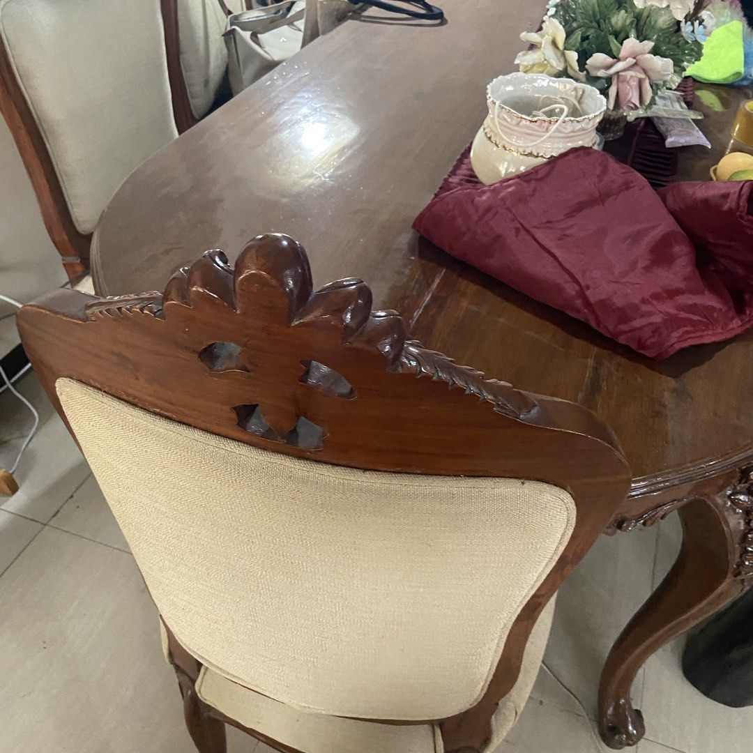 Vintage Wooden Dining Table with Chairs (Category: Tables & Sets) located in Paranaque City. Submitted by furniture_seller_jay (Listing ID 1439278599, Image 1). Description: Hardwood dining table set with 6 chairs. Heavy. Please be advised that two of the chairs are upholstered differently. Elegant antique dining table set. Features a large oval wooden table with intricately carved details on the legs and edges. Includes chairs with upholstered b