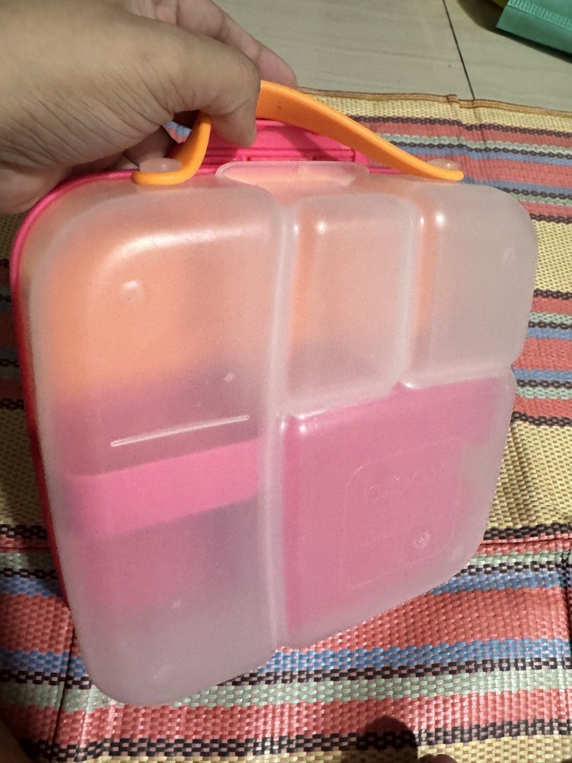 b.box Lunchbox - Pink (Category: Food Organization & Storage) located in Dasmarinas. Submitted by bookcollection27 (Listing ID 1439315176, Image 2). Description: B.box lunchbox in pink with orange accents. Features multiple compartments for different food items. Includes a handle for easy carrying. The lunchbox has a secure closing mechanism. The interior includes a removable divider and a small container. The exterior has the b.box logo. (gel ic