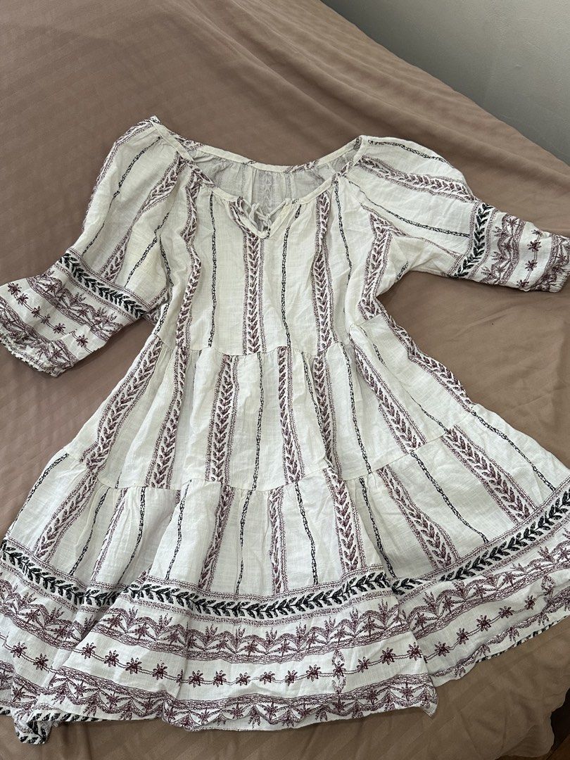 Bohemian White Dress (Category: Dresses) located in Davao. Submitted by beys.corner (Listing ID 1439337824, Image 2). Description: - Bohemian style white dress - V-neckline with tie detail - Short sleeves - Tiered skirt - Vertical striped pattern - Embroidered accents (brown and black) - Lightweight fabric.