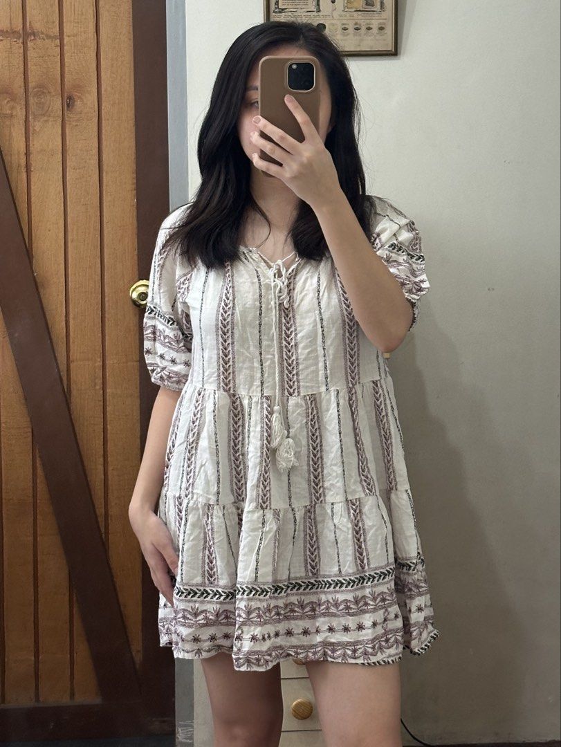 Bohemian White Dress (Category: Dresses) located in Davao. Submitted by beys.corner (Listing ID 1439337824, Image 1). Description: - Bohemian style white dress - V-neckline with tie detail - Short sleeves - Tiered skirt - Vertical striped pattern - Embroidered accents (brown and black) - Lightweight fabric.