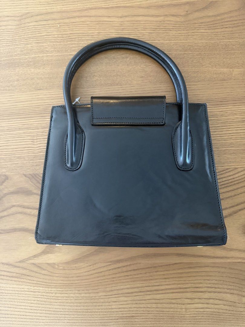 Vintage Orig Bruno Magli Black Structured Handbag (Category: Luxury Bags & Wallets) located in Mandaluyong City. Submitted by anditime (Listing ID 1439360121, Image 2). Description: - Black handbag - Gold-tone Bruno Magli logo - Top handle - Structured design - Interior zippered pocket - Protective feet - Classic and stylish.