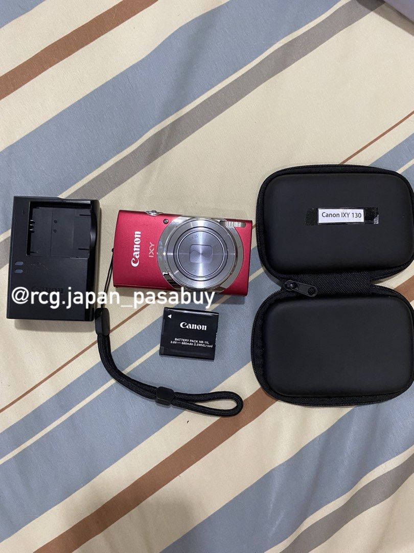 Canon IXY 130 Digital Camera (Category: Cameras) located in Legazpi City. Submitted by rcg.japan_pasabuy (Listing ID 1439381644, Image 1). Description: -₱8.8k sure buyer - Canon IXY 130 digital camera (red) - Includes charger, battery, and carrying case - Attached wrist strap - Displays 'No memory card' message - Features zoom lens and function buttons - Compact size.