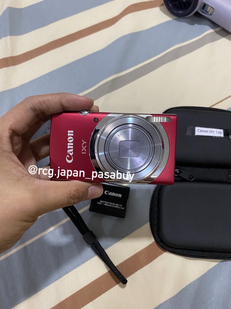 Canon IXY 130 Digital Camera (Category: Cameras) located in Legazpi City. Submitted by rcg.japan_pasabuy (Listing ID 1439381644, Image 2). Description: -₱8.8k sure buyer - Canon IXY 130 digital camera (red) - Includes charger, battery, and carrying case - Attached wrist strap - Displays 'No memory card' message - Features zoom lens and function buttons - Compact size.