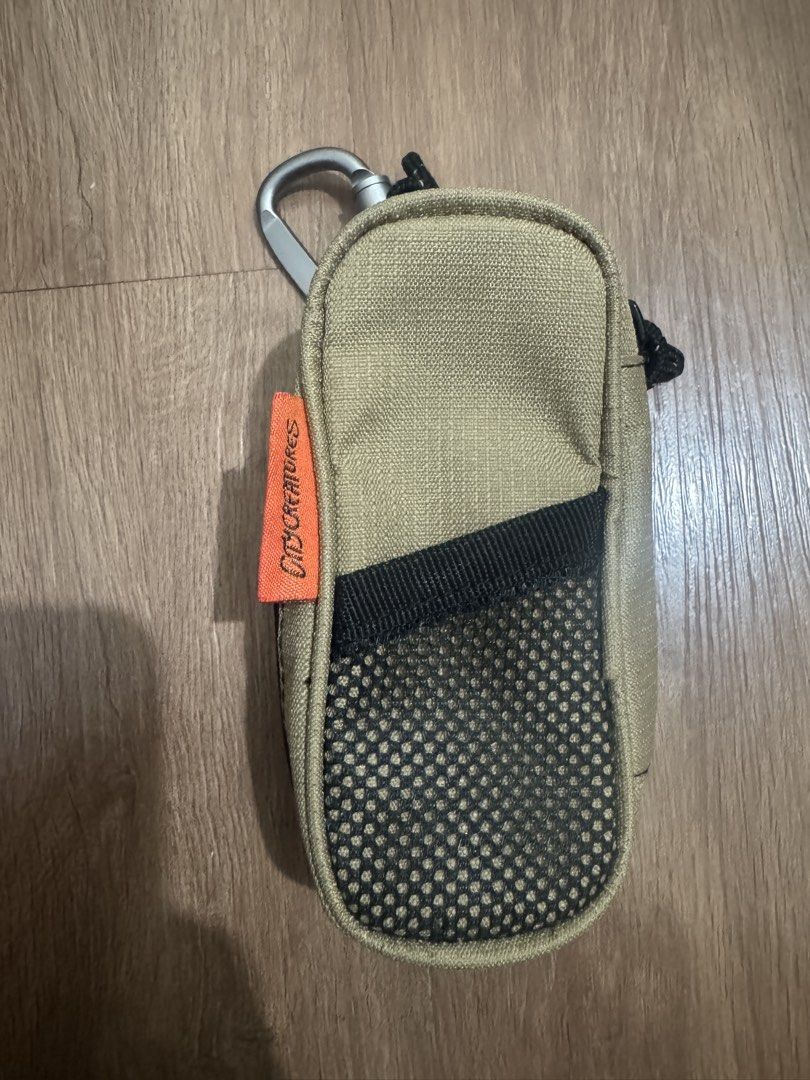 City creatures Pouch with Carabiner (Category: Purses & Pouches) located in Valenzuela. Submitted by fairythrift (Listing ID 1439346143, Image 2). Description: - Citycreatures pouch for small essentials. - Includes a mesh pocket and internal strap for organization. - Convenient carabiner for easy attachment. - Stylish tan exterior with a vibrant orange interior. - Secure zipper closure. - Features a small Citycreatures tag. This compact, speciali