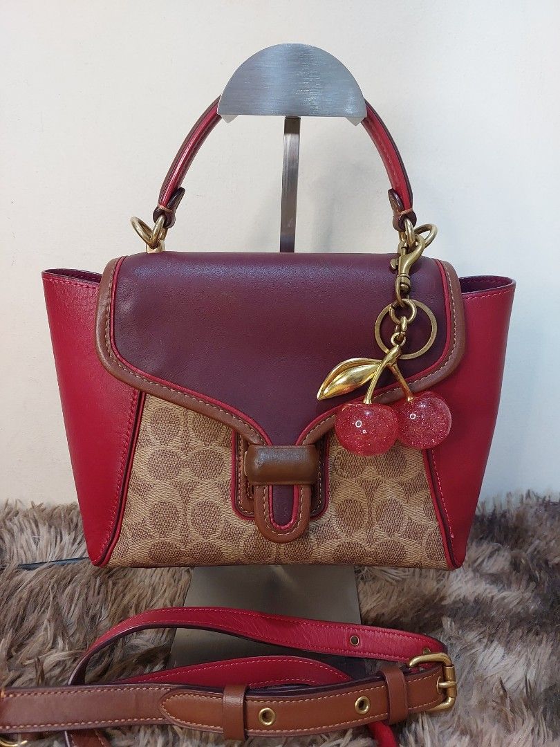 Coach Tabby Cherry Bag (Category: Luxury Bags & Wallets) located in Malabon City. Submitted by jullie_bag_shop (Listing ID 1439282544, Image 1). Description: - Coach Tabby bag with a charming cherry charm. - Features a detachable strap for versatile wear. - Signature pattern on the front. - Burgundy leather flap and base. - Gold-toned feet. - Top handle and secure zipper closure. - Interior includes a leather tag with Coach logo and serial number