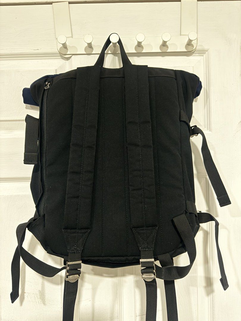 Coleman Journey Roll Top Backpack (Category: Backpacks) located in Cavite. Submitted by bertolomee (Listing ID 1439357430, Image 3). Description: Coleman Journey Roll Top Backpack features a roll-top design with adjustable straps and multiple compartments. It has a front zippered pocket and a padded back panel for comfort. The backpack is black with a navy blue top and includes the Coleman logo on the front..