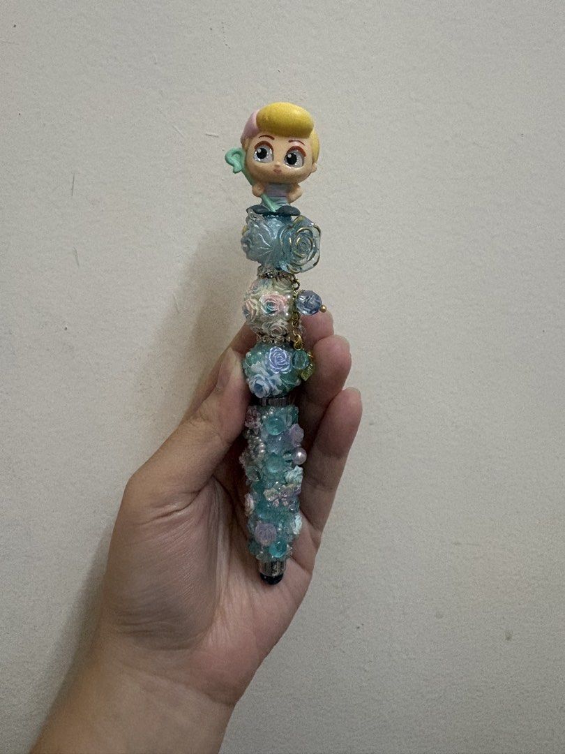 Doorable Bo Peep Pen Customized Decorative Pen (Category: Stationery & School Supplies) located in Manila. Submitted by alyannaros79007 (Listing ID 1439340665, Image 1). Description: - Unique, handcrafted pen - Decorative design with beads, flowers, and a toy topper - Turquoise and white color scheme - Ballpoint pen - Great for gifts or adding personality to your writing.
