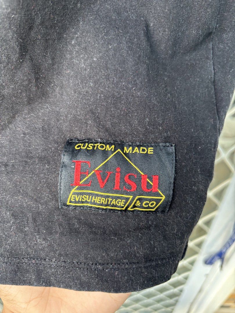 Evisu Graphic T-Shirt XL (Category: Tshirts & Polo Shirts ) located in Manila. Submitted by alexander_finds (Listing ID 1439311876, Image 3). Description: - Black Evisu t-shirt - Red logo on front - Graphic design on back with "Heritage" and "1991" - Size: XL - Includes custom Evisu tag.
