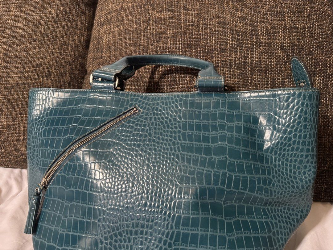 Fino Leatherware bag Teal Crocodile-Embossed Handbag (Category: Luxury Bags & Wallets) located in Manila. Submitted by jhayzel09 (Listing ID 1439274956, Image 3). Description: - Stylish teal handbag - Crocodile-embossed pattern - Top handle - Diagonal zipper detail with tassel accent - Rectangular shape with wider base - Glossy material bought at fino store robinsons magnolia no hidden issues lifetime warranty at all fino stores message me anytim