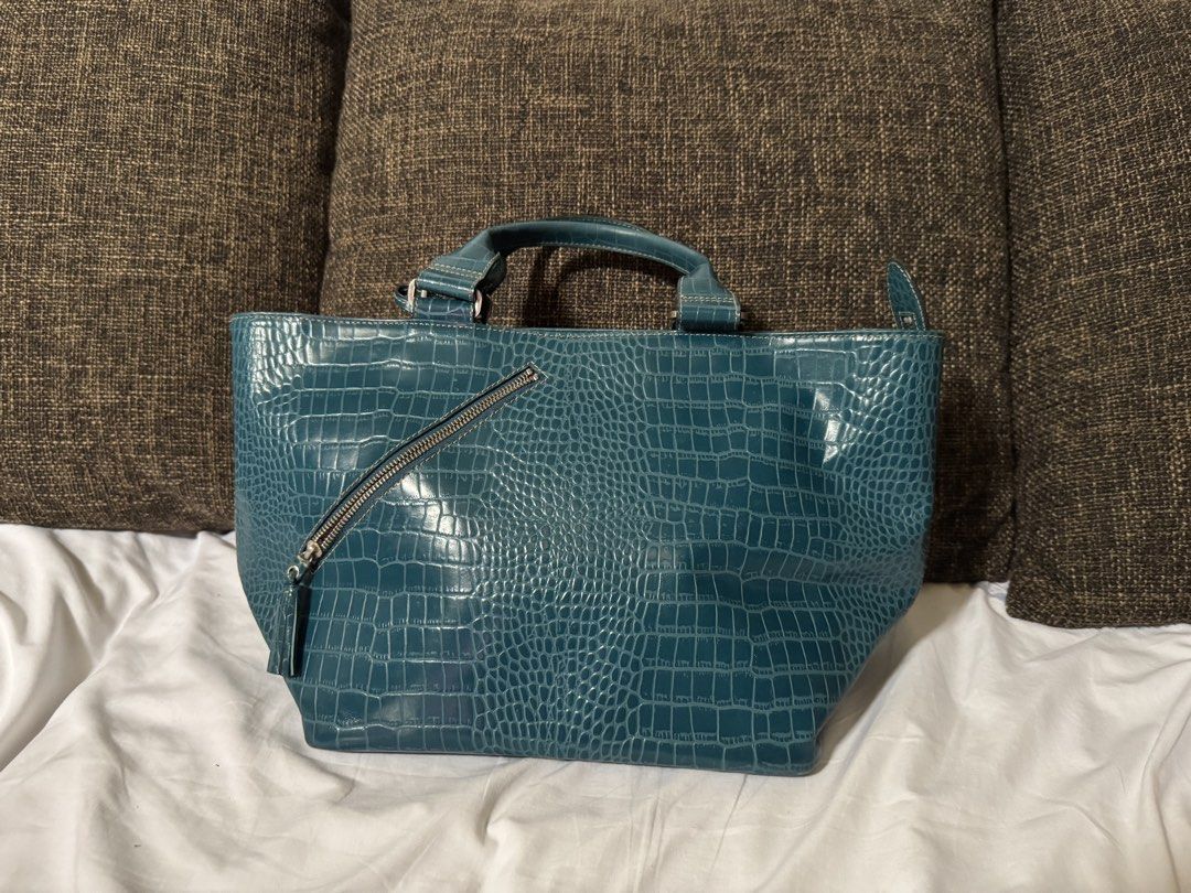 Fino Leatherware bag Teal Crocodile-Embossed Handbag (Category: Luxury Bags & Wallets) located in Manila. Submitted by jhayzel09 (Listing ID 1439274956, Image 1). Description: - Stylish teal handbag - Crocodile-embossed pattern - Top handle - Diagonal zipper detail with tassel accent - Rectangular shape with wider base - Glossy material bought at fino store robinsons magnolia no hidden issues lifetime warranty at all fino stores message me anytim