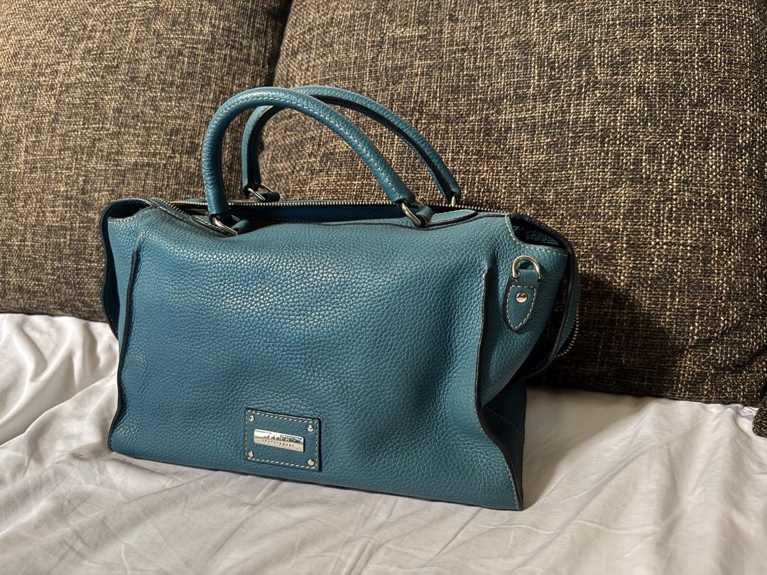 Fino Leatherware Teal Handbag (Category: Luxury Bags & Wallets) located in Manila. Submitted by jhayzel09 (Listing ID 1439276181, Image 2). Description: - Teal handbag from Pino Leatherware. - Dual top handles with long strap - Secure zip closure. - Includes front and back zippered pockets. - Made with textured leather. - Rectangular shape. - Metal brand plate on the front. bought at fino store robinsons magnolia very seldom used lifetime warrant