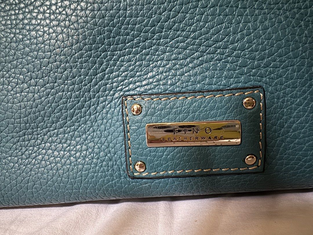 Fino Leatherware Teal Handbag (Category: Luxury Bags & Wallets) located in Manila. Submitted by jhayzel09 (Listing ID 1439276181, Image 3). Description: - Teal handbag from Pino Leatherware. - Dual top handles with long strap - Secure zip closure. - Includes front and back zippered pockets. - Made with textured leather. - Rectangular shape. - Metal brand plate on the front. bought at fino store robinsons magnolia very seldom used lifetime warrant