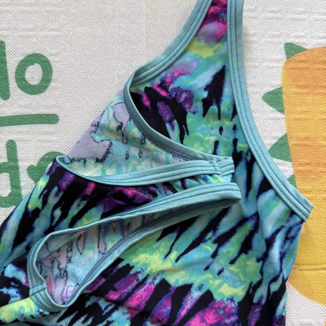 Girls' Tie-Dye Swimsuit (Category: Babies & Kids Fashion) located in Davao. Submitted by taycodissimo_apparel (Listing ID 1439288911, Image 3). Description: - Girls' tie-dye swimsuit - Vibrant pattern in blue, green, purple, and black - Scoop neck design - Light blue trim - Made of stretchy material - Comfortable for swimming and beach days.