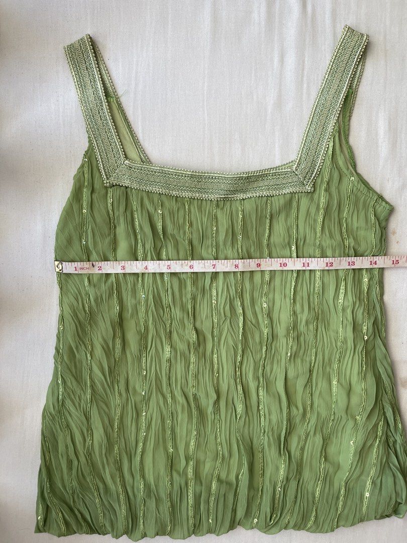Green sleeveless top with sequins (no brand) (Category: Sleeveless) located in Quezon City. Submitted by andreabaut (Listing ID 1439323083, Image 2). Description: - Stretchy fabric (bust can fit up to 36 in) - Sleeveless top in light green - Unique pleated design with subtle sequin accents - Square neckline - Decorative trim on straps RFS: doesn’t fit anymore.