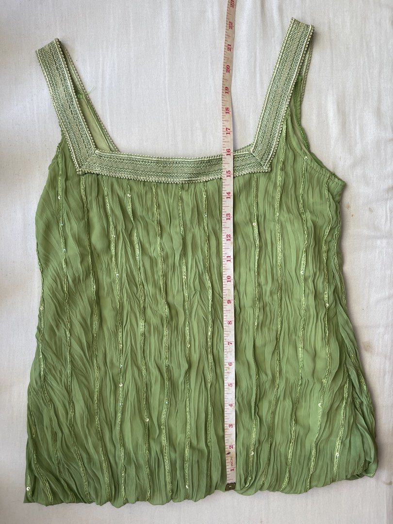 Green sleeveless top with sequins (no brand) (Category: Sleeveless) located in Quezon City. Submitted by andreabaut (Listing ID 1439323083, Image 1). Description: - Stretchy fabric (bust can fit up to 36 in) - Sleeveless top in light green - Unique pleated design with subtle sequin accents - Square neckline - Decorative trim on straps RFS: doesn’t fit anymore.