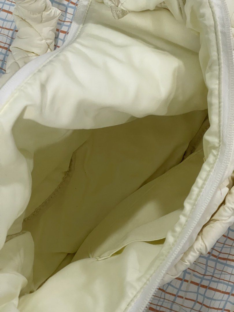 GU Puffer Cream Quilted Shoulder Bag (Category: Shoulder Bags) located in Quezon City. Submitted by ewyeung (Listing ID 1439308610, Image 3). Description: - Cream-colored quilted shoulder bag - Unique knotted strap design - Spacious interior - Zipper closure - Small interior pocket - Made of soft, padded material - Minor stain on exterior.