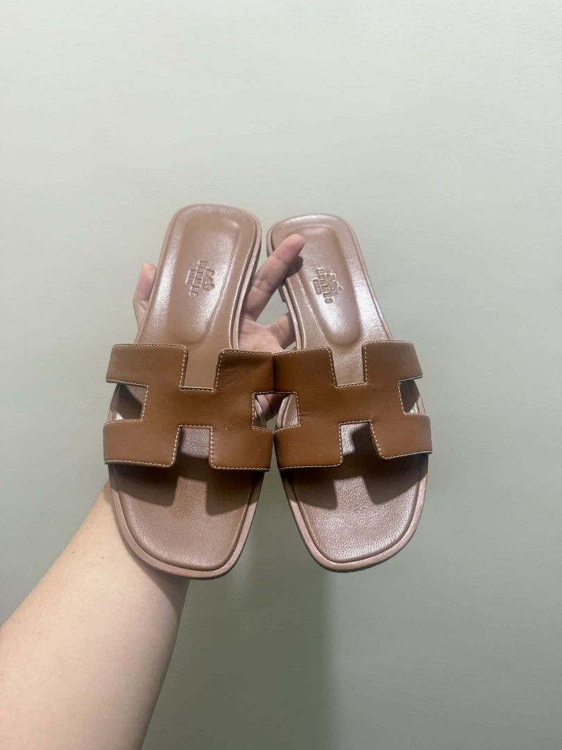Hermes Oran Sandals - Brown - Size 38 (Category: Flats & Sandals) located in Manila. Submitted by newowl.293cb5 (Listing ID 1439282662, Image 1). Description: - Authentic Hermes Oran sandals - Color: Brown - Size: 38 - Iconic H cut-out design - Made in Italy - Condition: Good, with wear on soles - Perfect for everyday wear.
