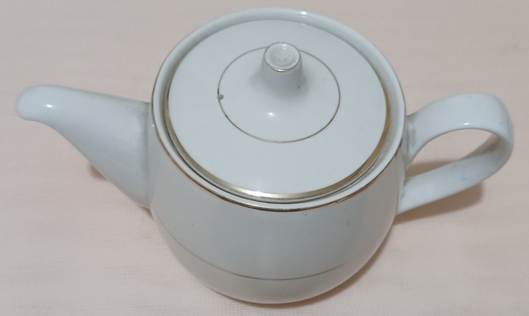 Hoya Ivory China Teapot (Category: Coffee & Tea Tableware) located in Quezon City. Submitted by wjmae (Listing ID 1439274399, Image 2). Description: - White teapot with lid. - Features silver trim on lid and band around the body. - Brand: "Hoya Ivory China". - Made in Japan. - Includes handle and spout..