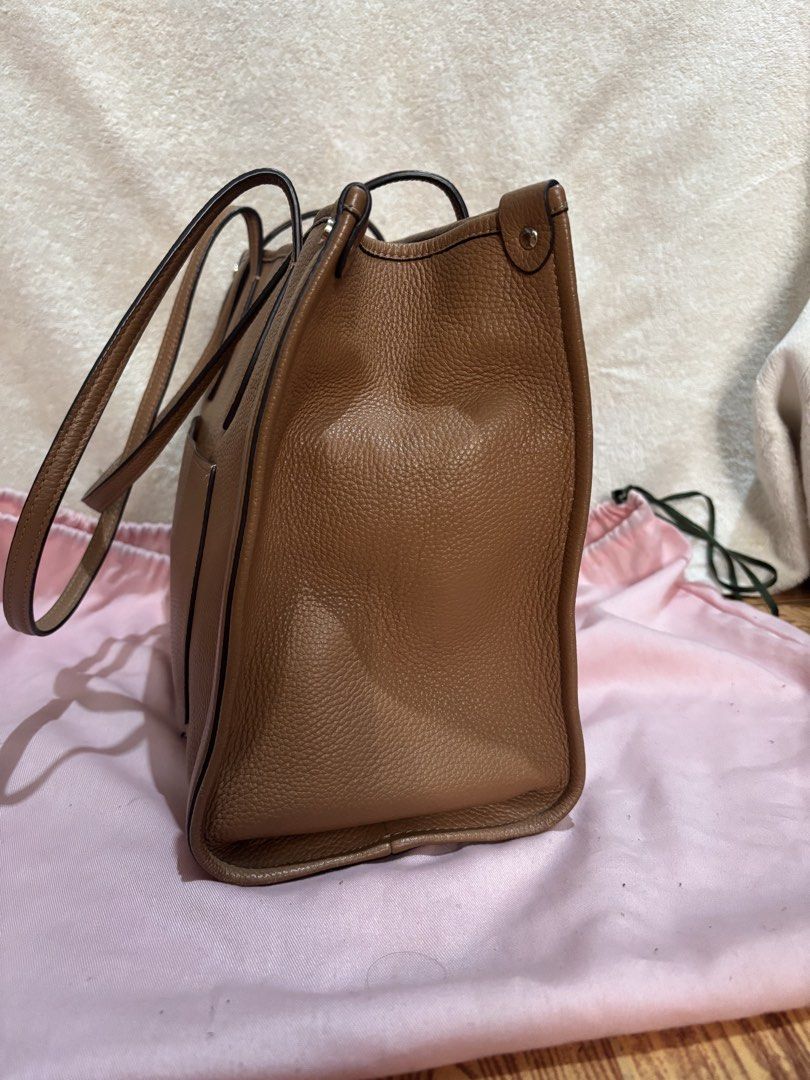 Kate Spade Brown Leather Tote Bag (Category: Tote Bags) located in Cainta. Submitted by rey0325 (Listing ID 1439355089, Image 3). Description: - Kate Spade brown leather tote bag - Rectangular shape - Top handles - Detachable yellow tag - Simple design - Kate Spade logo on the front - Made of textured leather.