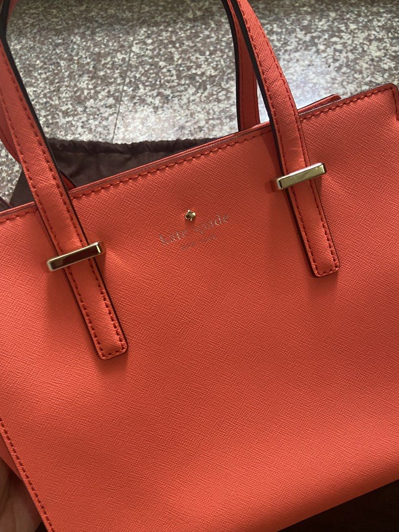 Kate Spade Coral Handbag with Shoulder Strap (Category: Luxury Bags & Wallets) located in San Pablo. Submitted by vernikas (Listing ID 1439272677, Image 3). Description: - Authentic Kate Spade handbag - Coral color - Detachable shoulder strap - Gold-toned hardware - Top zipper closure - Includes dust bag and care card - Interior with patterned lining and small pocket - Structured design - Two top handles.