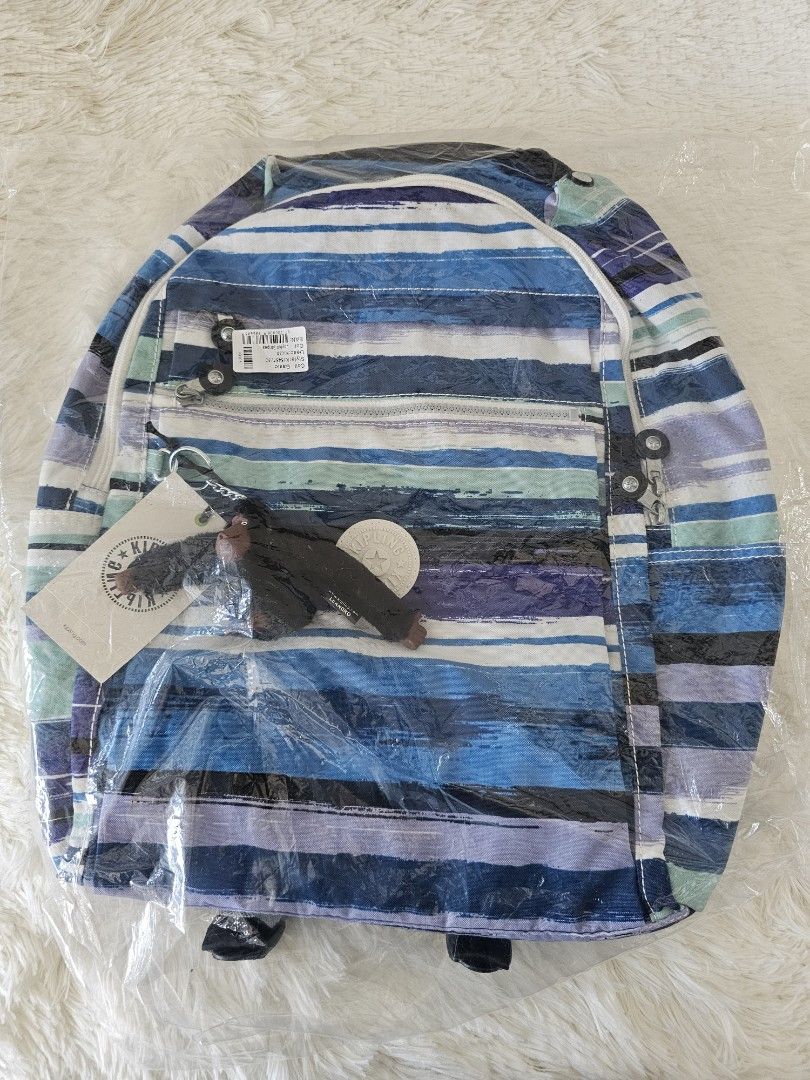 Kipling Backpack with Blue Stripes (Category: Backpacks) located in Taguig. Submitted by ljdm_22 (Listing ID 1439276928, Image 2). Description: - Brand new Kipling backpack - Eye-catching blue striped design - Multiple compartments for storage - Includes front zippered pocket and side pockets - Comes with the iconic Kipling monkey keychain - Adjustable straps for a comfortable fit - Top handle for easy carrying - Still in original packaging - fre