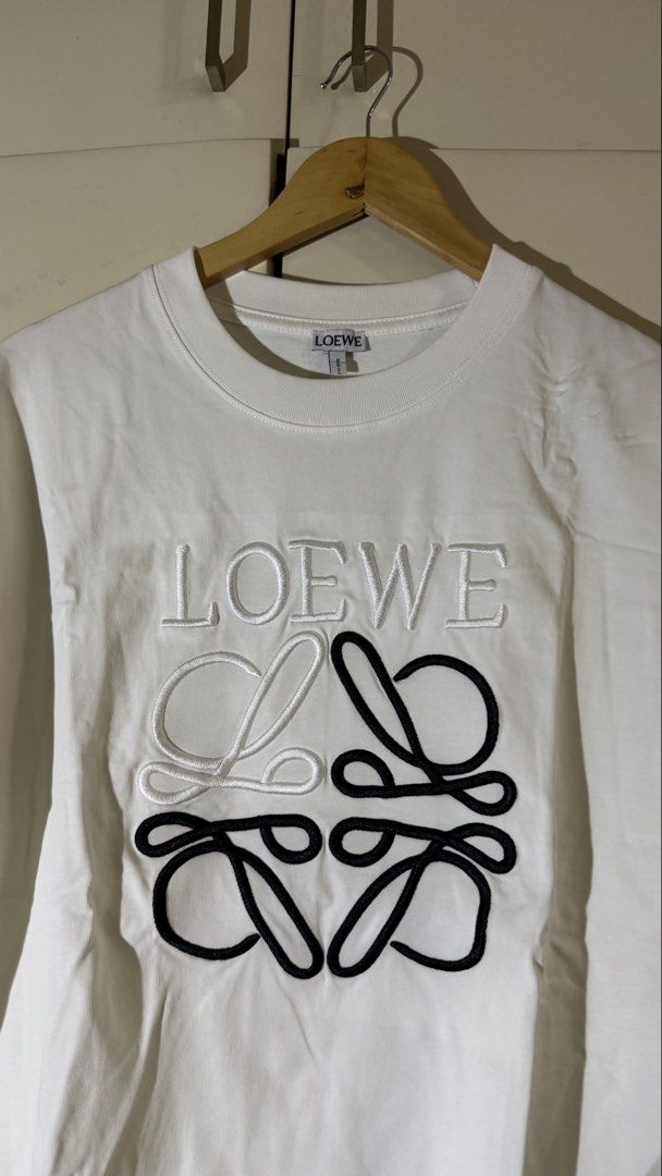 Loewe Embroidered Logo T-shirt (Category: Tshirts & Polo Shirts ) located in Quezon City. Submitted by mogsmogs (Listing ID 1439391678, Image 2). Description: - Loewe white t-shirt - Embroidered logo on front - Made in Portugal - 100% cotton - Crew neck - Short sleeves Dimes: 22 width x 27 length Rfs: nakatambak sa closet, tumaba ako.