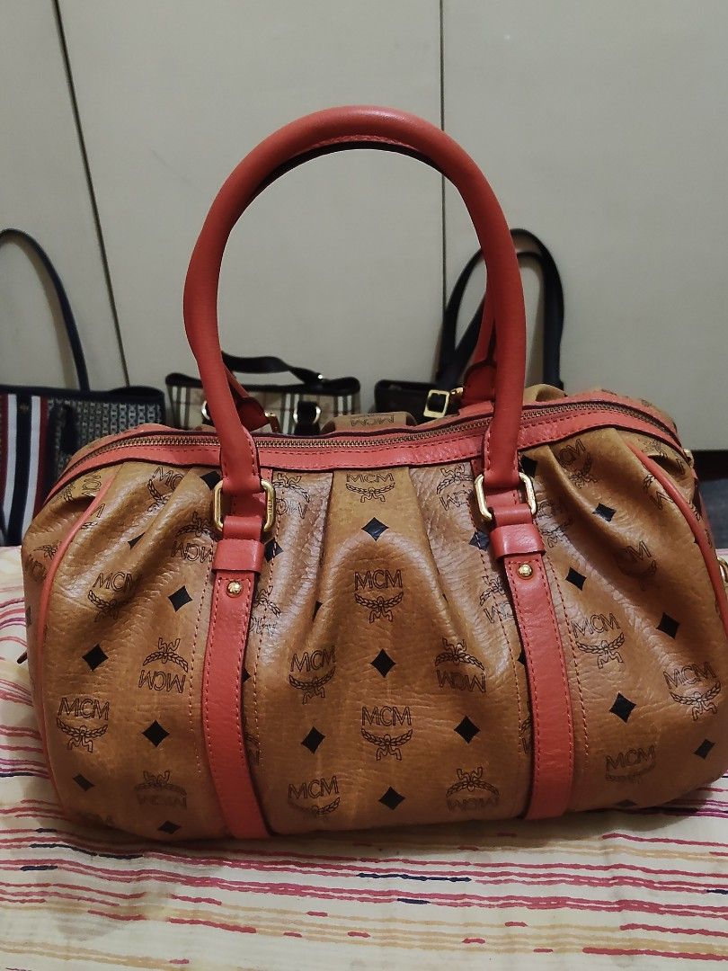 Original MCM Boston Bag (Category: Luxury Bags & Wallets) located in Cebu City. Submitted by almzcorner (Listing ID 1439252771, Image 2). Description: - Authentic MCM Boston bag - Classic monogram pattern - Red leather handles and accents - Gold-tone hardware - Secure zip closure - Spacious interior - MCM logo plate with serial number.