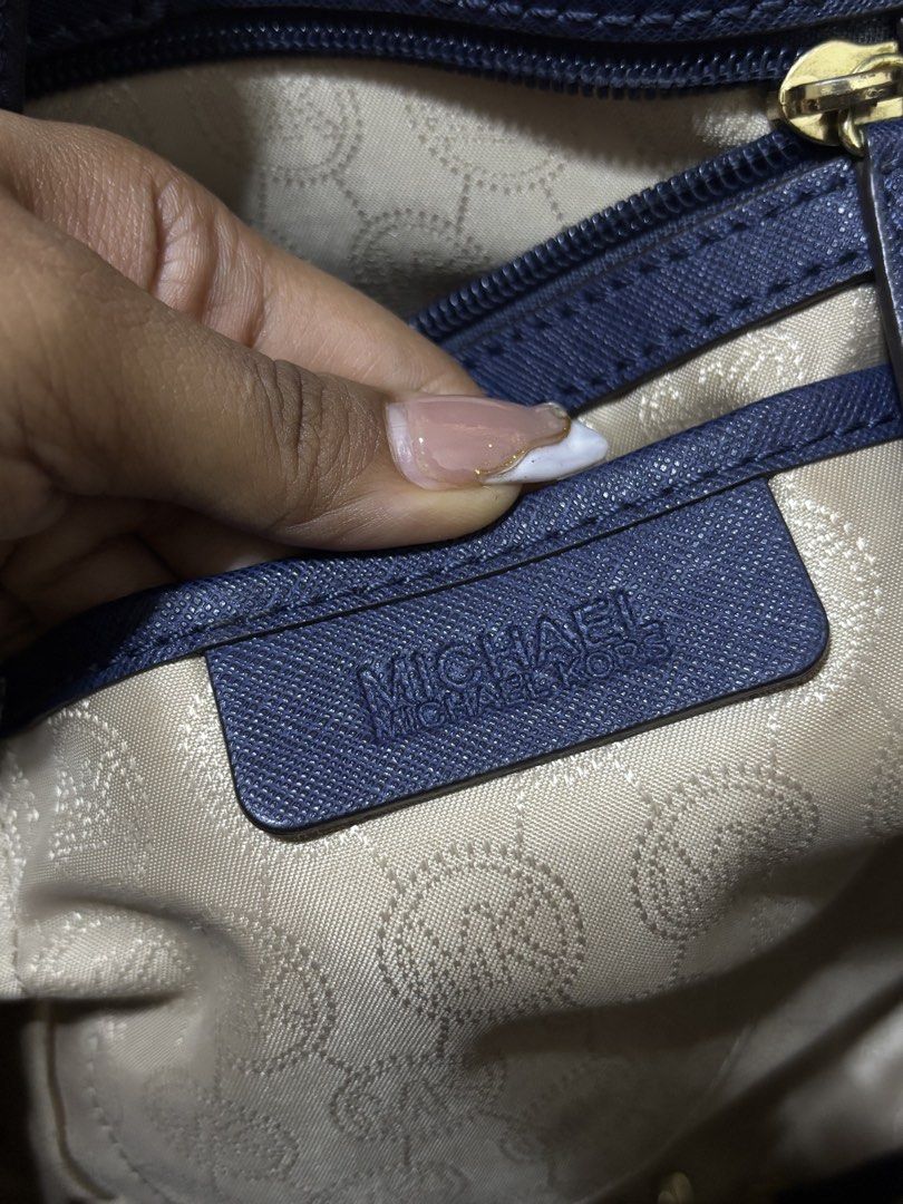 Michael Kors Navy Blue Satchel Bag (Category: Luxury Bags & Wallets) located in Aloran. Submitted by aezamirae (Listing ID 1439296525, Image 3). Description: - Authentic Michael Kors satchel bag - Navy blue color - Top handle and detachable shoulder strap - Gold-tone MK logo charm - Gold-tone hardware - Multiple interior compartments - Branded lining - Michael Kors logo on zippers Negotiable.