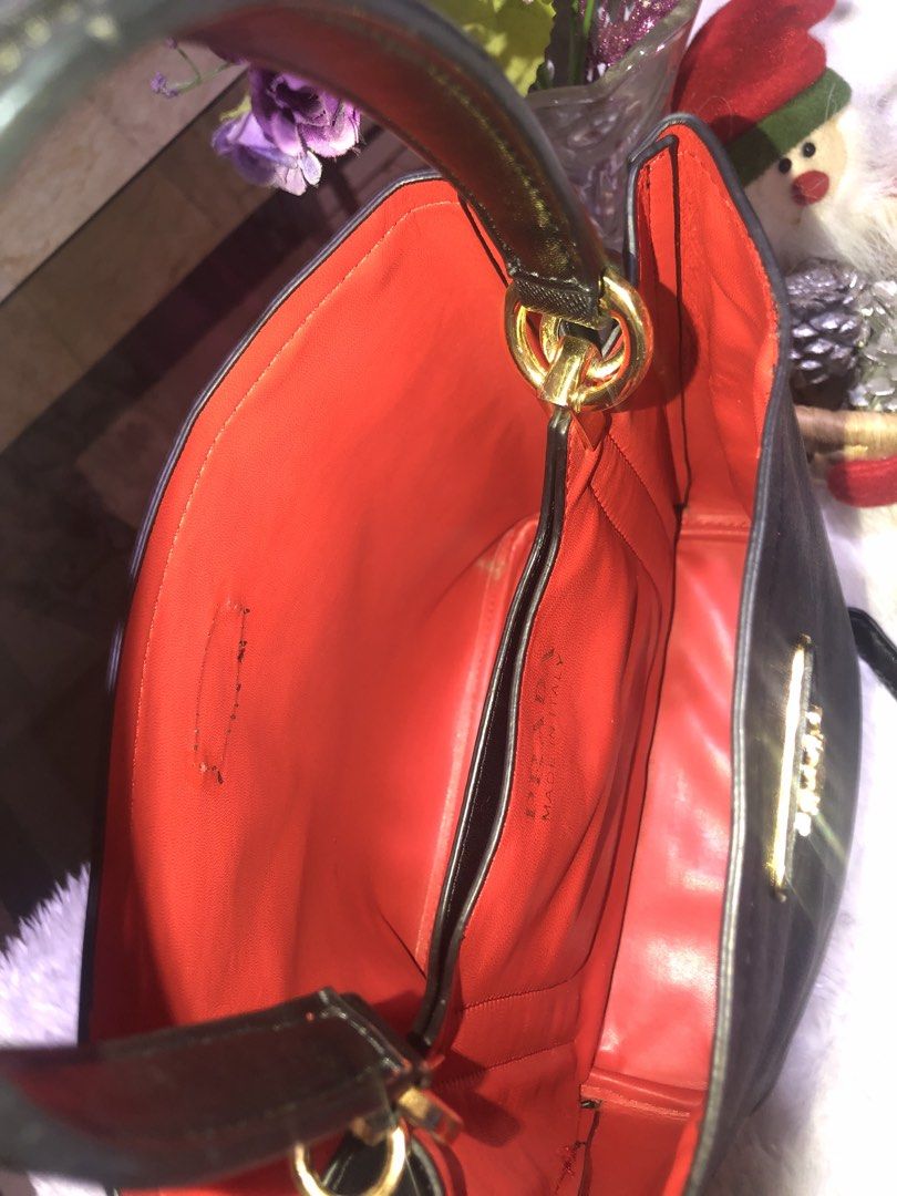 Prada Black Handbag with Red Interior (Category: Luxury Bags & Wallets) located in Meycauayan. Submitted by miletteaqu82717 (Listing ID 1439305000, Image 2). Description: - not guaranteed Prada handbag - Classic black exterior - Striking red interior - Gold Prada logo and hardware - Detachable black strap - Structured shape with top handles - Interior pocket with Prada label - no lock major flaw.