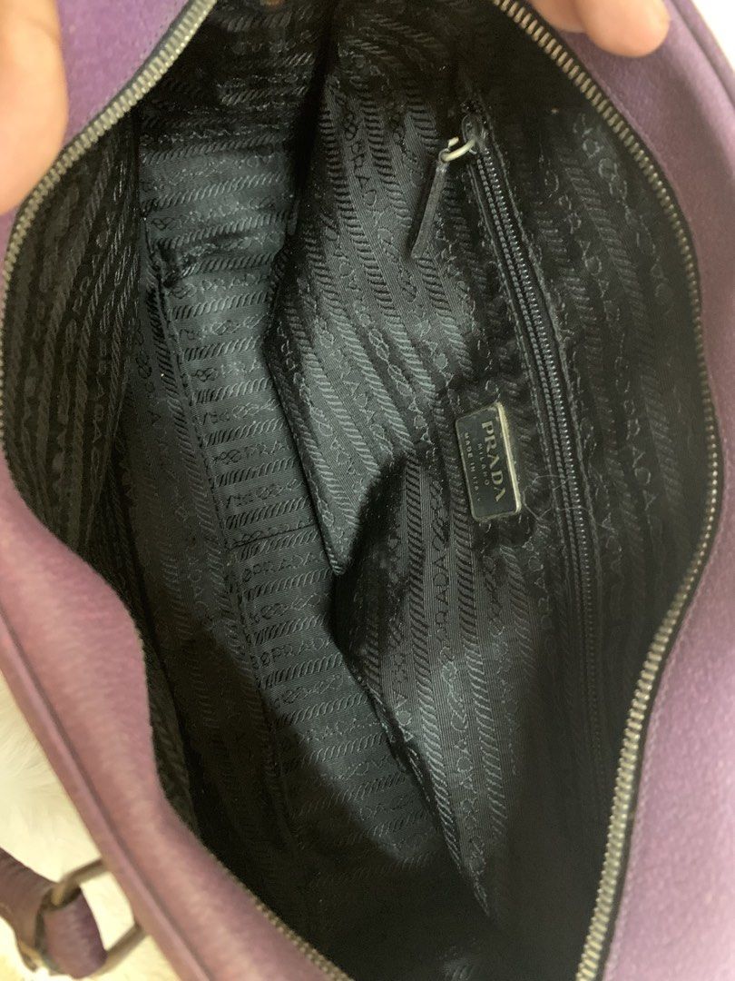 Prada Purple Leather Handbag (Category: Luxury Bags & Wallets) located in Manila. Submitted by _.d4awnn (Listing ID 1439308889, Image 3). Description: Authentic Prada handbag in a beautiful purple color. Features a leather exterior with a zip closure. The interior is lined with Prada-branded fabric and includes an interior pocket. Comes with authenticity cards. The bag has a unique design with a handle and a decorative ring detail..