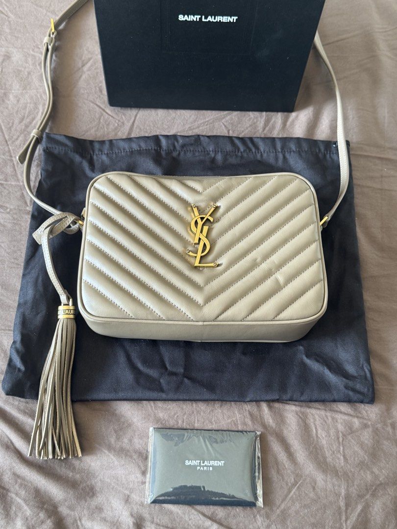 Saint Laurent Lou Camera Bag (Category: Luxury Bags & Wallets) located in Manila. Submitted by reinjsph (Listing ID 1439315120, Image 1). Description: Saint Laurent Lou Camera Bag features a quilted design and a gold-tone YSL logo. It has a tassel detail and comes with a dust bag and box. The bag has a shoulder strap and a rectangular shape..