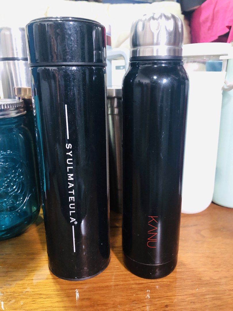 SYULMATEULA and KANU Water Bottles (Category: Water Bottles & Tumblers) located in Manila. Submitted by noemiaspa1702 (Listing ID 1439282732, Image 1). Description: - Two black insulated water bottles - Brand 1: SYULMATEULA - Cylindrical shape - Screw-on lid - Brand 2: KANU - Silver, textured lid.