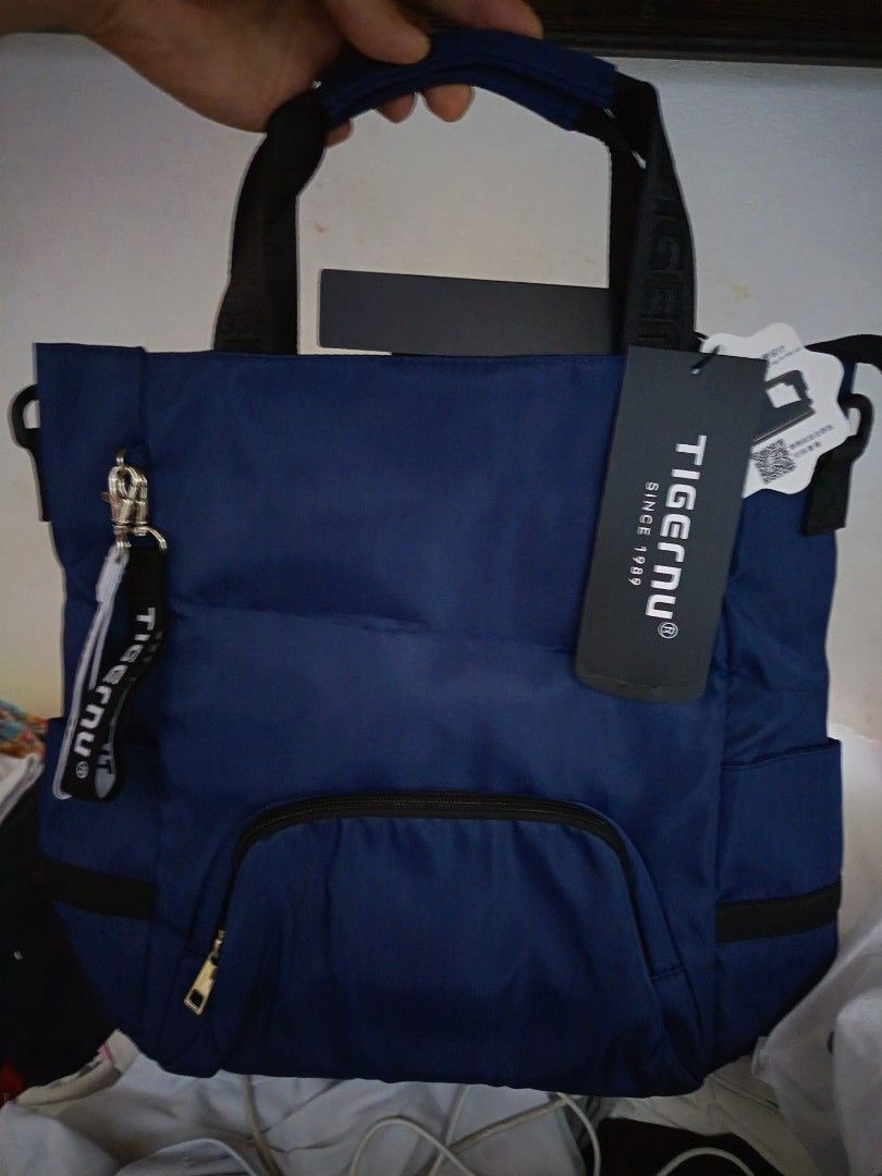Tigernu Cross-body Bag (Category: Cross-body Bags) located in Manila. Submitted by mookiemonster (Listing ID 1439380495, Image 1). Description: - Tigernu cross-body bag - Navy blue color - Fits laptops up to 15.6 inches - Front pocket - Detachable strap included - Comes with a keychain - Zipper closure - New with tags - Comfortable design.