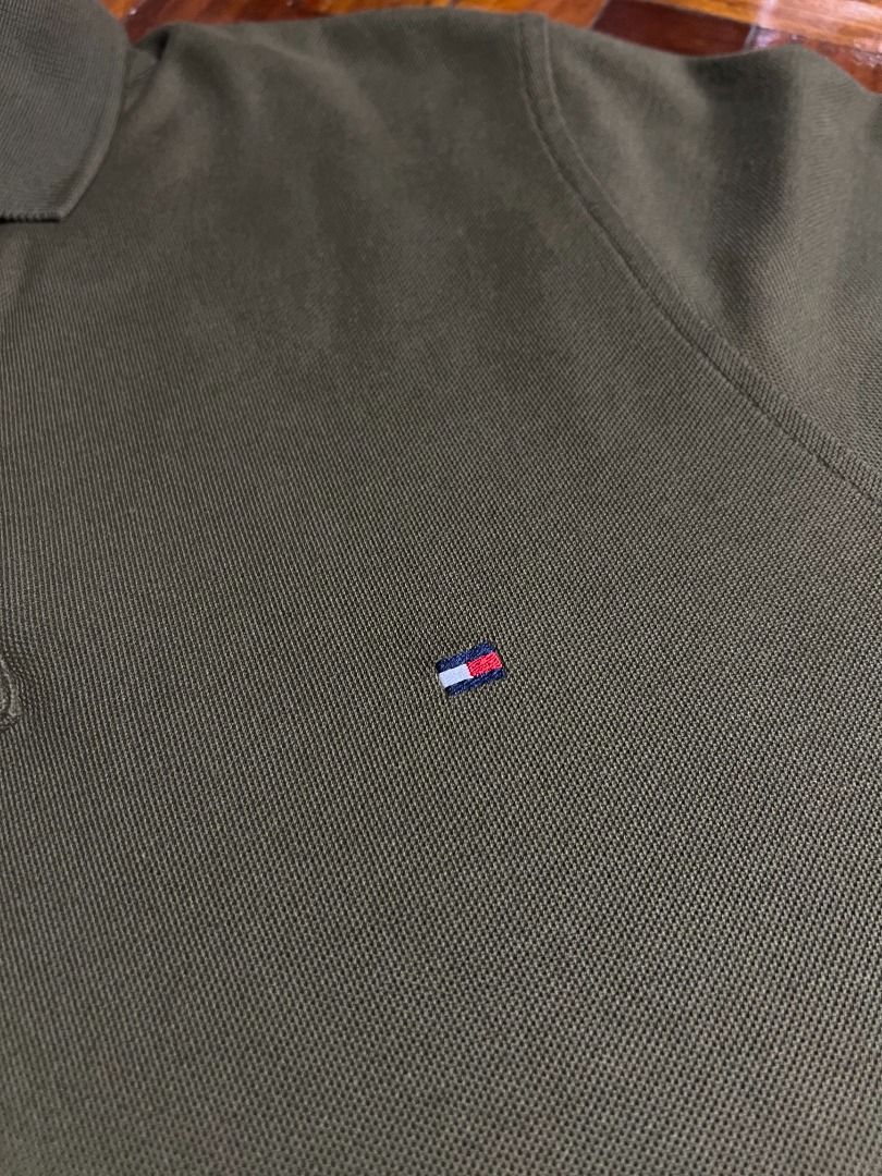 Tommy Hilfiger Polo Shirt (Category: Tshirts & Polo Shirts ) located in Quezon City. Submitted by don.fitss (Listing ID 1439345818, Image 3). Description: - Olive green Tommy Hilfiger polo shirt - Classic polo collar with blue and white striped inner lining - Short sleeves - Three-button placket - Tommy Hilfiger logo on chest - Made of textured fabric.