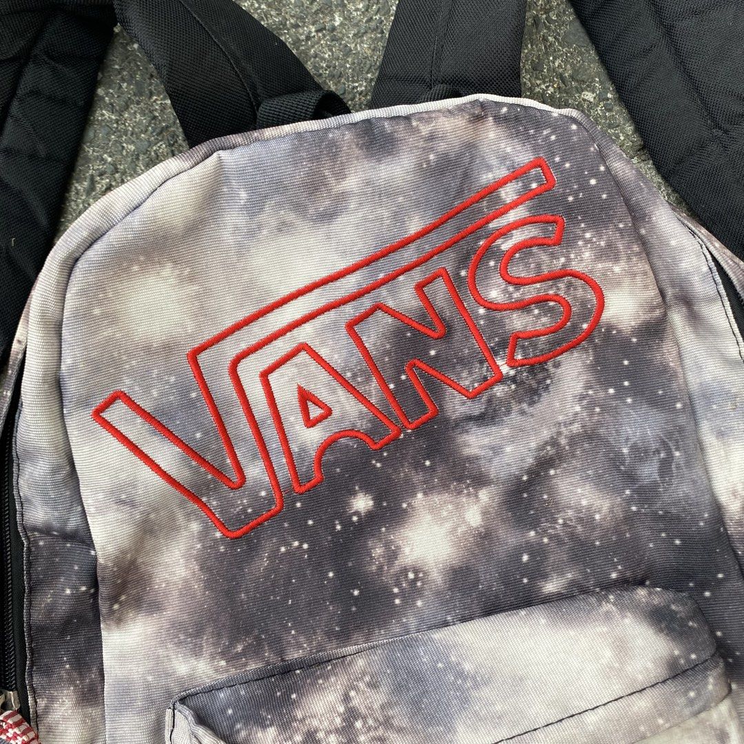 Vans Backpack (Category: Backpacks) located in Manila. Submitted by shi.vimn (Listing ID 1439253932, Image 3). Description: Vans backpack features a unique galaxy print. It has a front pocket and padded shoulder straps for comfort. The Vans logo is prominently displayed in red. It's a stylish and functional choice for carrying essentials..