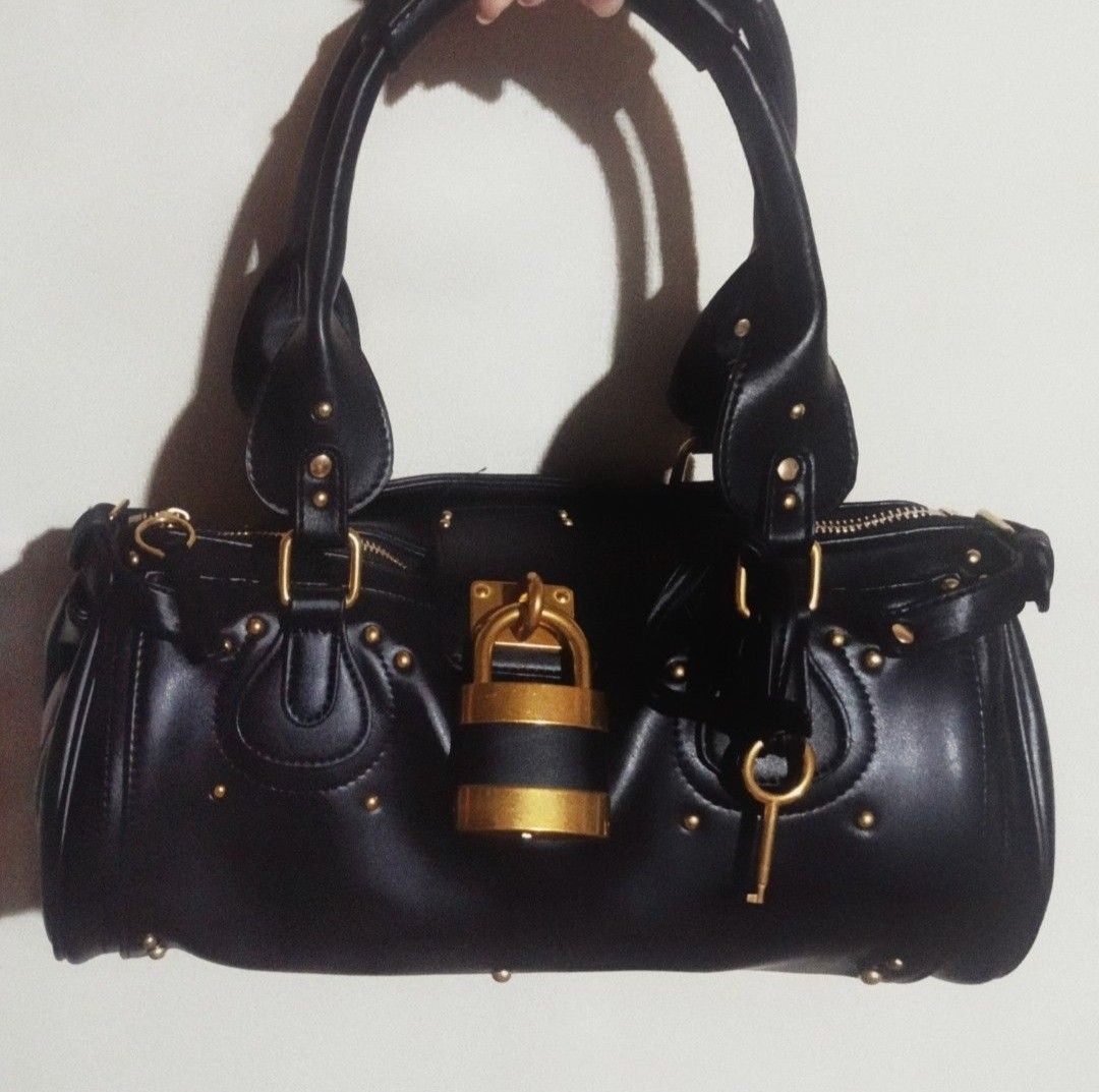 Vintage Bag (Category: Luxury Bags & Wallets) located in Muntinlupa City. Submitted by allychino (Listing ID 1439374082, Image 1). Description: Insp. Paddington handbag NO BRAND INDICATED Php 1,850 - Color: Black - Gold-tone hardware - Iconic padlock and key detail - Top handles - Zip closure - Studded accents - Classic satchel shape Loc: Tunasan, Muntinlupa City.