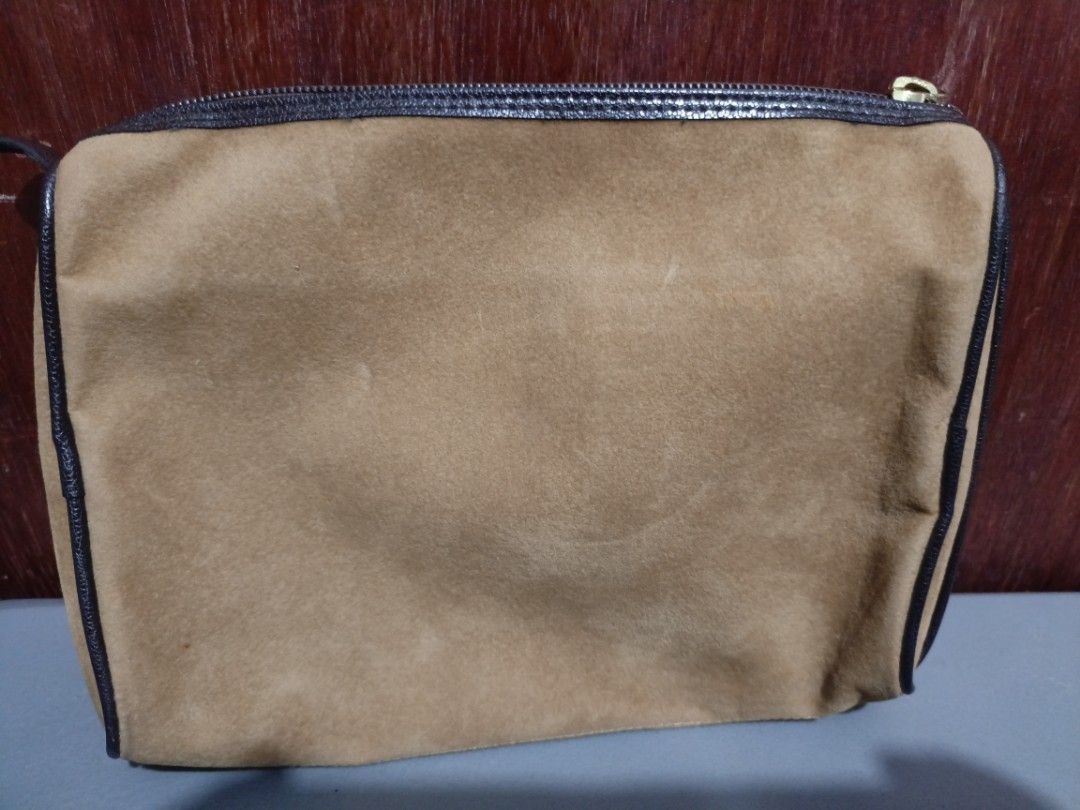 Vintage Brown Clutch Bag (Category: Clutches) located in San Jose del Monte. Submitted by m_nshop (Listing ID 1439348768, Image 3). Description: - Vintage clutch bag - Brown suede exterior - Dark brown trim - Gold-toned zipper - Small oval emblem - Light-colored interior lining - Rectangular shape PRELOVED NEEDS CLEANING AND WASHING FROM JAPAN AUCTION NO COD PAYMENT FIRST LALAMOVE OR JNT COURIER NO LBC.