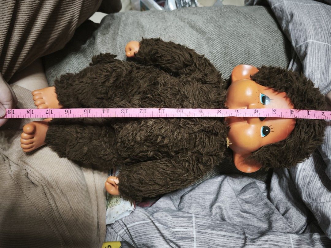 Vintage Monchichi Doll (Category: Kids Toys) located in Manila. Submitted by anisik.collectibles.haven.2021 (Listing ID 1439319805, Image 2). Description: - Vintage Monchhichi doll - Brown fur body and hair - Plastic face, hands, and feet - Blue eyes, smiling face - Approximately 19cm long - Minor marks on hands - A classic collectible toy.