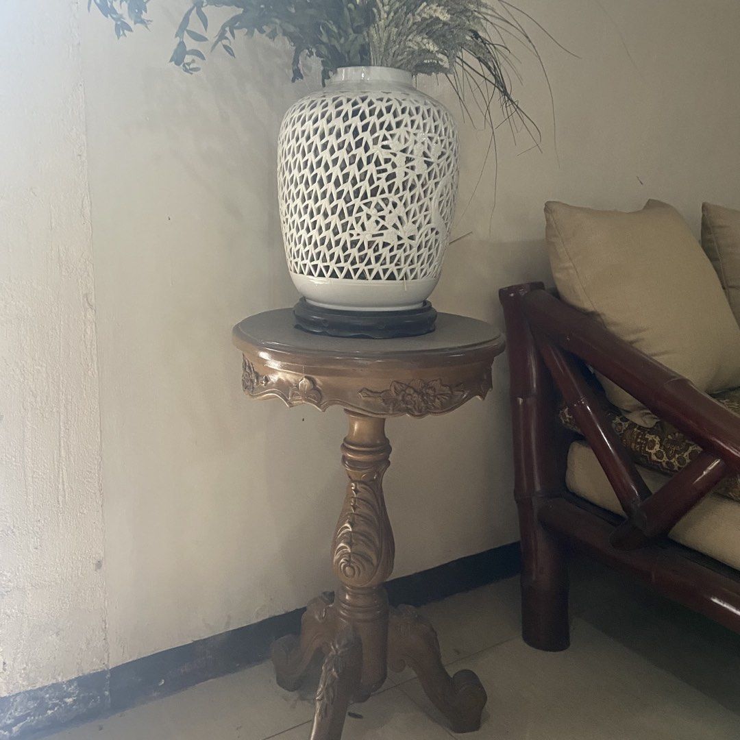 Vintage Wooden Side Table (Category: Tables & Sets) located in Paranaque City. Submitted by furniture_seller_jay (Listing ID 1439272187, Image 1). Description: Vase and table “Blanc de Chine” style pierced (reticulated) ceramic jar Hand-carved pedestal table, likely made of a local hardwood like Narra or Mahogany - Vintage side table - Carved floral design - Round tabletop - Ornate pedestal base - Warm golden finish - Ideal for decorative items o