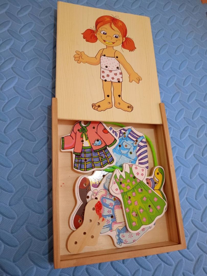 Wooden Threading Dress-Up Puzzle (Category: Educational & Learning Toys) located in Pasig City. Submitted by rochej (Listing ID 1439287292, Image 1). Description: - Wooden puzzle with a girl figure. - Includes a lace and various clothing pieces to practice threading. - Clothing options: dresses, overalls, jacket, and shoes. - Comes with a wooden box for storage..