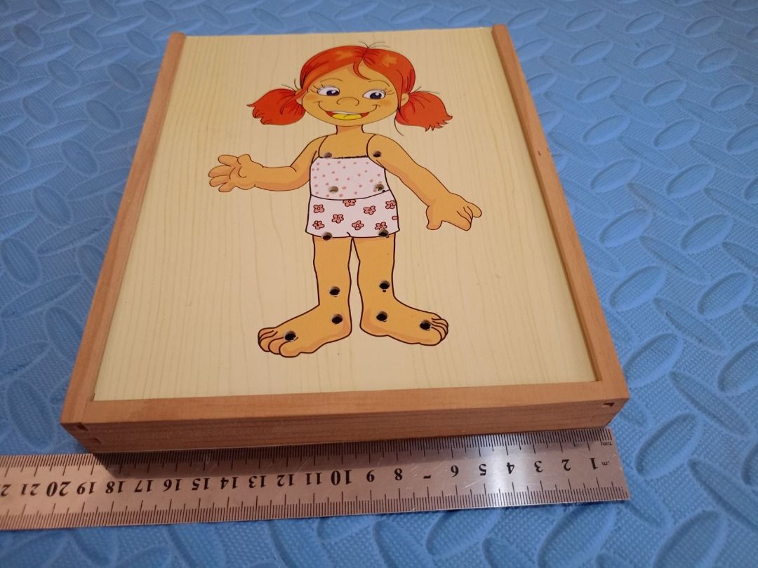 Wooden Threading Dress-Up Puzzle (Category: Educational & Learning Toys) located in Pasig City. Submitted by rochej (Listing ID 1439287292, Image 3). Description: - Wooden puzzle with a girl figure. - Includes a lace and various clothing pieces to practice threading. - Clothing options: dresses, overalls, jacket, and shoes. - Comes with a wooden box for storage..