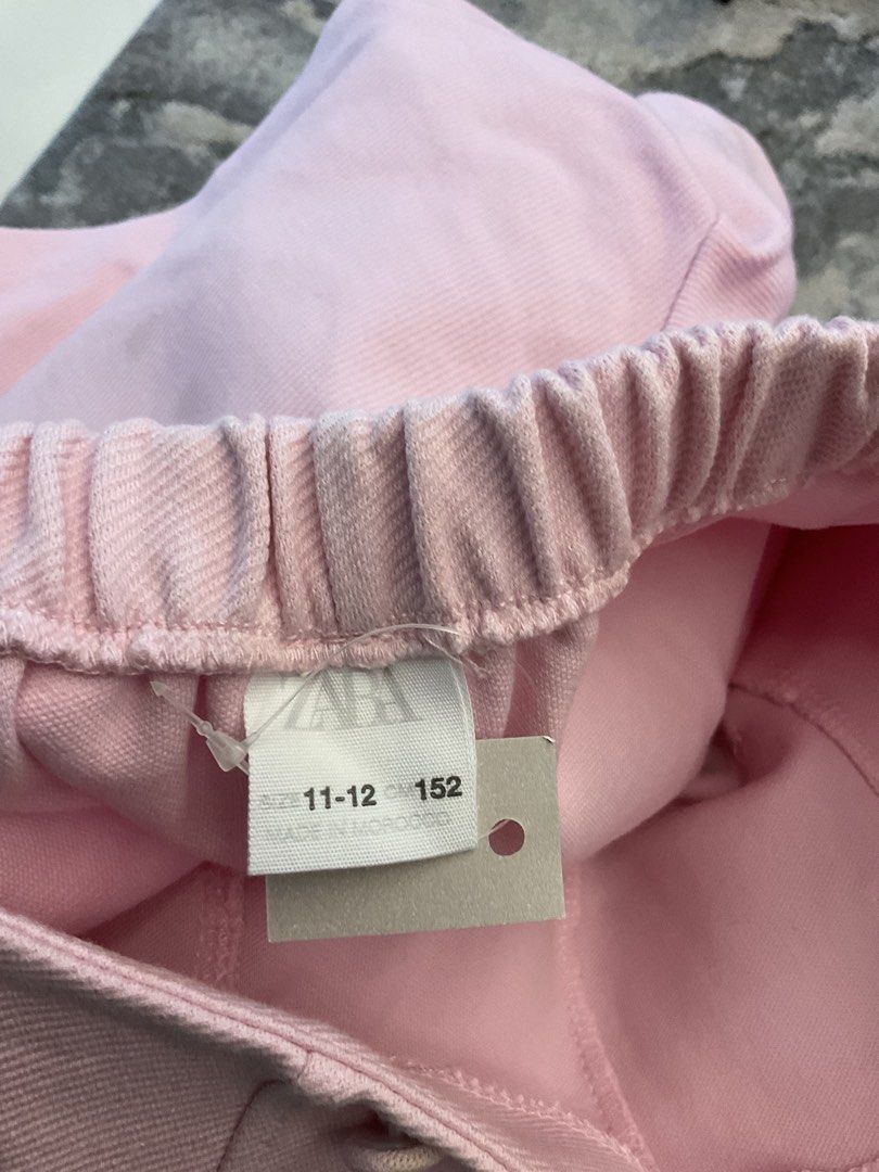 Zara Pink High-Waisted Shorts (Category: Babies & Kids Fashion) located in Antipolo. Submitted by ibyangs_closet (Listing ID 1439284350, Image 3). Description: These stylish pink shorts from Zara feature a high-waisted design with decorative buttons. They have an elastic waistband for a comfortable fit. The shorts are a light pink color and appear to be made of a smooth fabric. The size is indicated as 11-12, corresponding to a CM size of 152. Ma