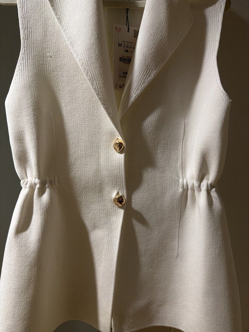 Zara White Vest with Gold Buttons (Category: Sleeveless) located in Quezon City. Submitted by branded_closet01 (Listing ID 1439260847, Image 2). Description: - Zara white vest - Size M - Tailored design - Lapel collar - Two gold buttons - Elasticated waist detail - Made in China - Original price: 2595 PHP.