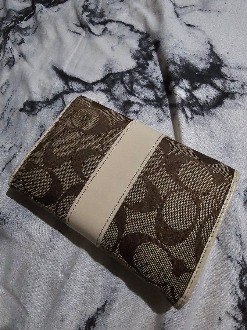 (Authentic) Coach Signature Wallet (Category: Luxury Bags & Wallets) located in Manila. Submitted by cclamb (Listing ID 1439589567, Image 2). Description: - Coach wallet with signature pattern - Multiple card slots - Compartments for cash and essentials - Snap closure - Interior: Light cream color - Exterior: Brown and tan color scheme -Guaranteed authentic with care card - See pics for condition and flaws -RFS: New wallet.