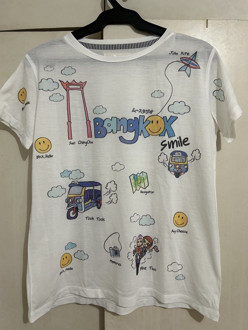 Bangkok Graphic T-shirt (Category: Shirts) located in Quezon City. Submitted by samthingsshop (Listing ID 1439566916, Image 1). Description: Bought in Bangkok - White t-shirt perfect for summer weather - Features a vibrant Bangkok-themed graphic - Design includes: tuk-tuk, Giant Swing, map, and smiley faces - Short sleeves - Crew neck - Plain white back.